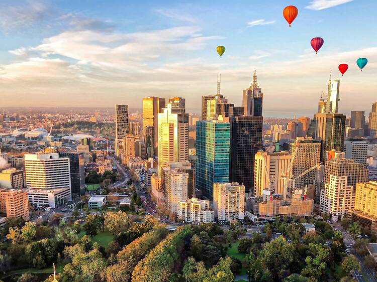 Hot air balloons over the Melbourne skyline at sunrise